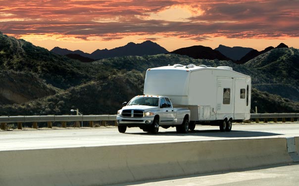 A Dodge dually truck pulling a 5th wheel through the mountains