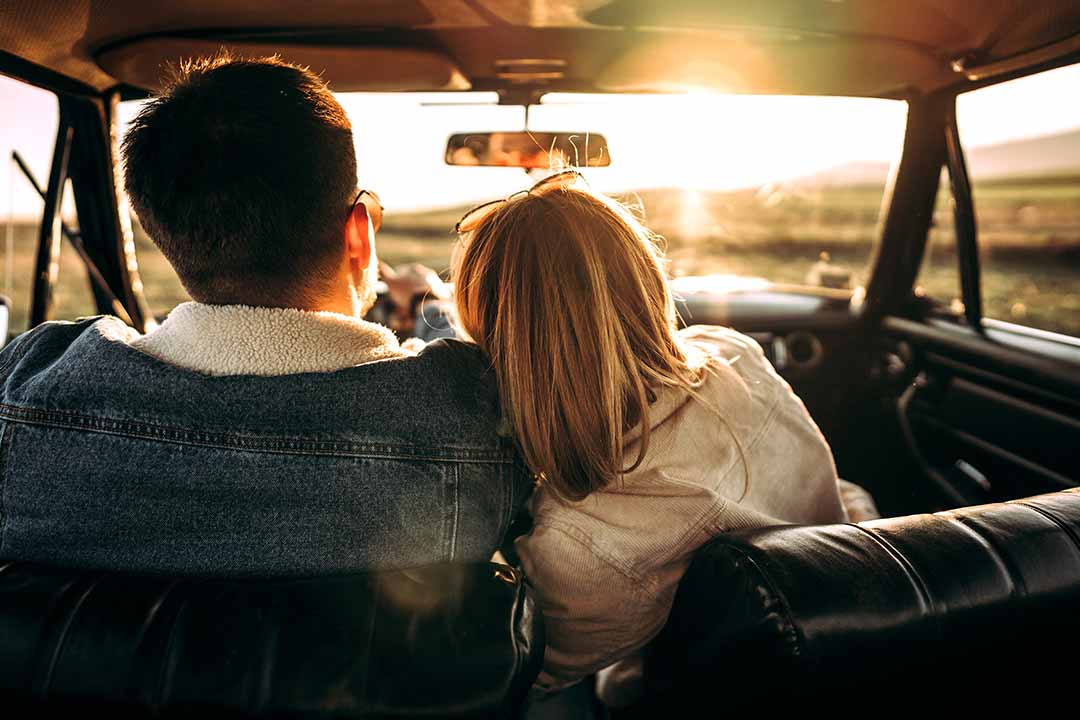 couple in car watching sunset